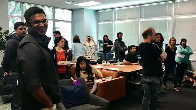 Verizon Media CEO Guru Gowrappan smiles at the camera while standing among a group of employees at the opening of Verizon Media's accessibility lab.