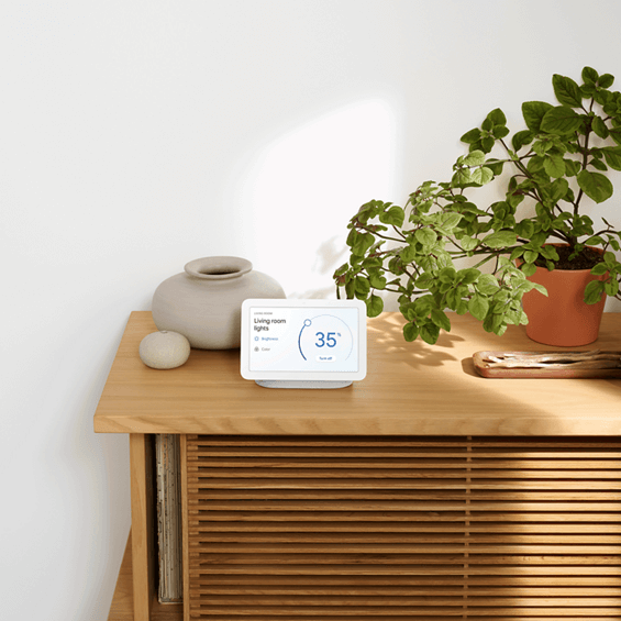 Lifestyle photo showing the Google Nest Hub (2nd Gen) on a side table.